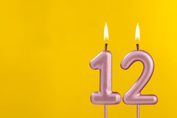 Birthday candle number 12 - Birthday celebration on yellow background