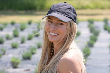 Portrait off a smiling woman wearing a black baseball cap in summer