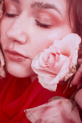 Fototapeta premium Pink portraits of a young girl with red roses on her face