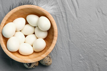 Bowl of boiled quail eggs on grey background