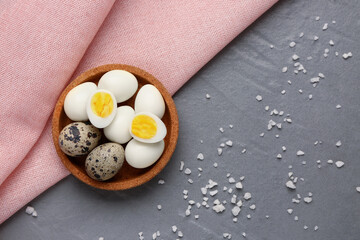 Bowl of boiled quail eggs on grey background