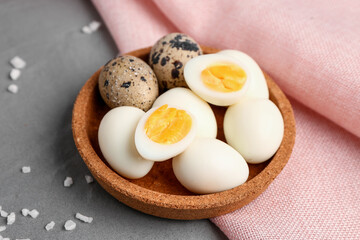 Bowl of boiled quail eggs on grey background