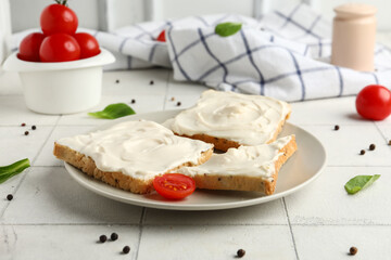 Plate of tasty toasts with cream cheese on table