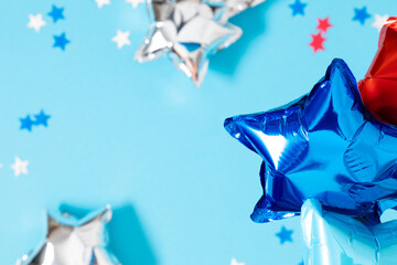 4th of July, USA Presidents Day, Independence Day. Flat lay top view of  celebration decor inflatable star balloons twinkling confetti on blue background, promotion or greeting message, banner