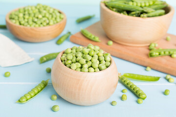 Composition with fresh green peas on wooden table