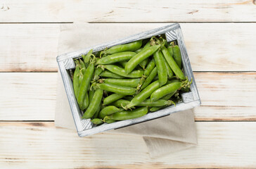 Composition with fresh green peas on wooden background, top view