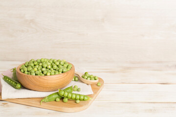 Composition with fresh green peas on wooden table
