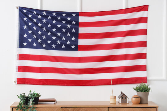 USA flag hanging on light wall in living room