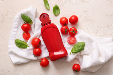 Bottle of ketchup and tomatoes on white background