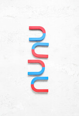 Horseshoe shaped magnets on textured white background
