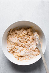 Loosely folded bread dough in a white bowl, bread dough, low hydration dough, process of making bread