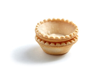 Two empty tartlet shells isolated on white. Crispy mini tart shells closeup