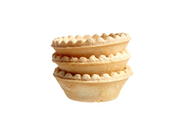 Three empty tartlet shells isolated on white. Stack of crispy mini tart shells closeup, selective focus
