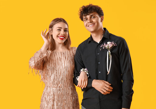 Beautiful prom couple on yellow background