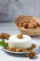 Piece of fresh goat cheese with walnuts. healthy food. Mediterranean cuisine.