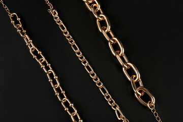 Fototapeta na wymiar Beautiful chain bracelets on black background