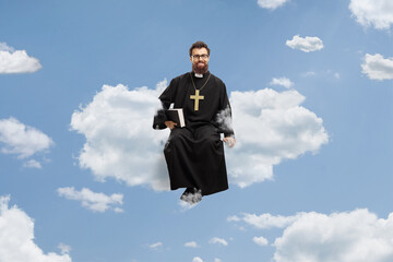 Priest sitting on a cloud and holding a bible