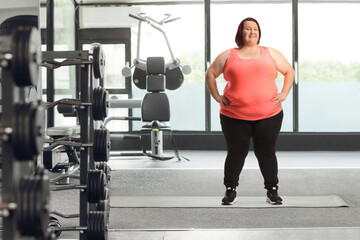 Overweight in sportswear posing in a gym