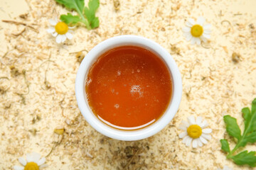 Composition with bowl of honey, fresh and dried chamomile flowers on color background