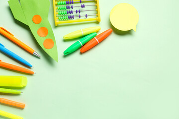 Naklejka premium Paper rocket with abacus, different stationery and speech bubble on green background