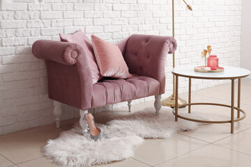 Cozy pink armchair, coffee table and fur rug white brick wall