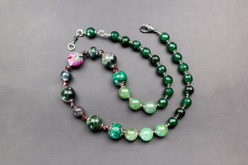 Statement green and pink stone bead necklace on black, unique handmade jewelry background, massive unusual jewelry, promotional photo for an online jewellery store