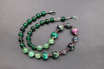 Statement green and pink stone bead necklace on black, unique handmade jewelry background, massive unusual jewelry, promotional photo for an online jewellery store