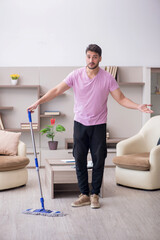 Young male contractor cleaning the house