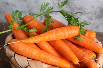 Wicker basket with fresh carrots, closeup