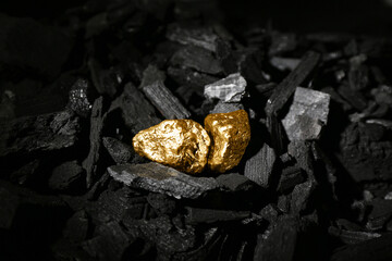 Golden nuggets on black charcoal