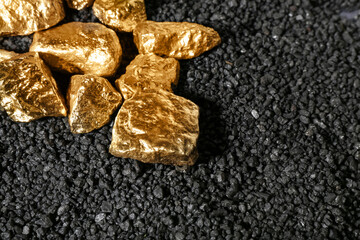 Golden nuggets on black coal, closeup