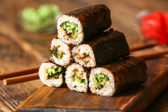 Tasty maki rolls on wooden background