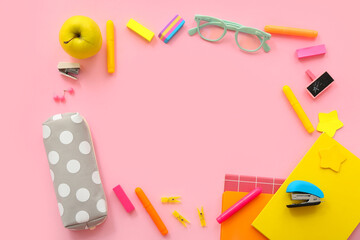 Frame made of fresh apple, eyeglasses and different stationery on pink background