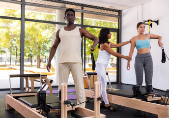 African american man doing pilates exercises lying on pilates workout machines