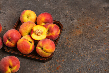 Fototapeta na wymiar Tray with sweet peaches on dark background