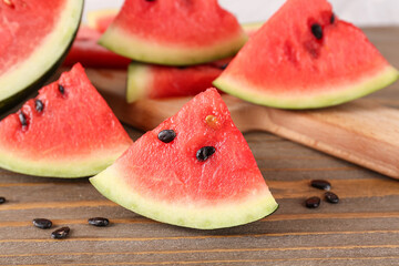 Board with pieces of fresh watermelon and seeds on wooden table