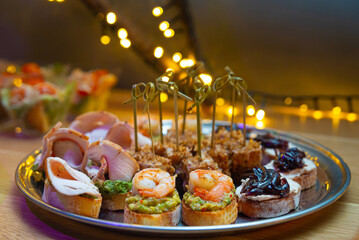 Set of bruschetta and canapes on a plate. Tapas with guacamole and prawn, tapas with caramelized...