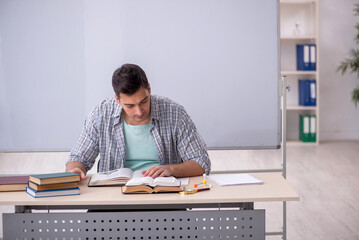 Young male student sitting in the classroom