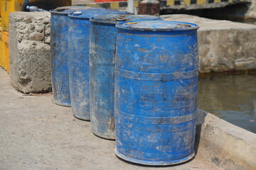 Selective focus of chemical tank with black lid on ground floor, blue plastic tank to hold auctioned fish.