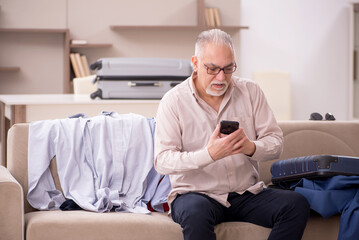 Old man preparing for trip at home