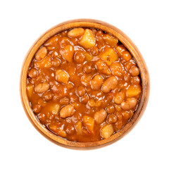 Lentil and bean stew, in a wooden bowl. French stew of brown lentils, white beans, potatoes, tomatoes, onions and herbs, cooked in liquid and served in the resultant gravy. Close-up, macro food photo.