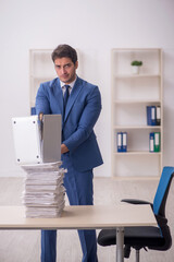 Young male employee unhappy with excessive work in the office