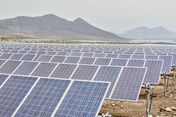 Photo of rows of solar panels in a field with mountains in the background"CHI_2017_8515_det_aff_tpz_result.jpg