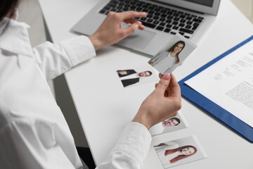 Human resources manager choosing employee among different applicants at table, closeup