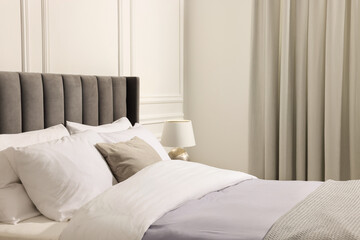 Fototapeta na wymiar Comfortable bed and lamp in bedroom. Interior design