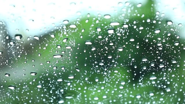 車の窓ガラスに降る雨の水滴