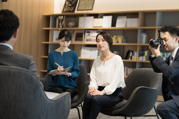 Scene of a corporate interview with the president at the company Multiple cameramen and reporters