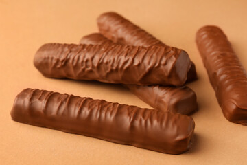 Sweet tasty chocolate bars on beige background, closeup