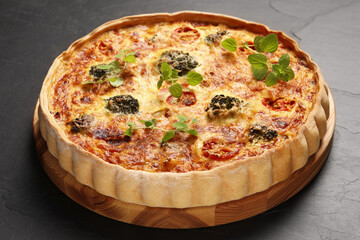 Delicious homemade vegetable quiche on dark table