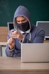 Young male hacker sitting in the classroom